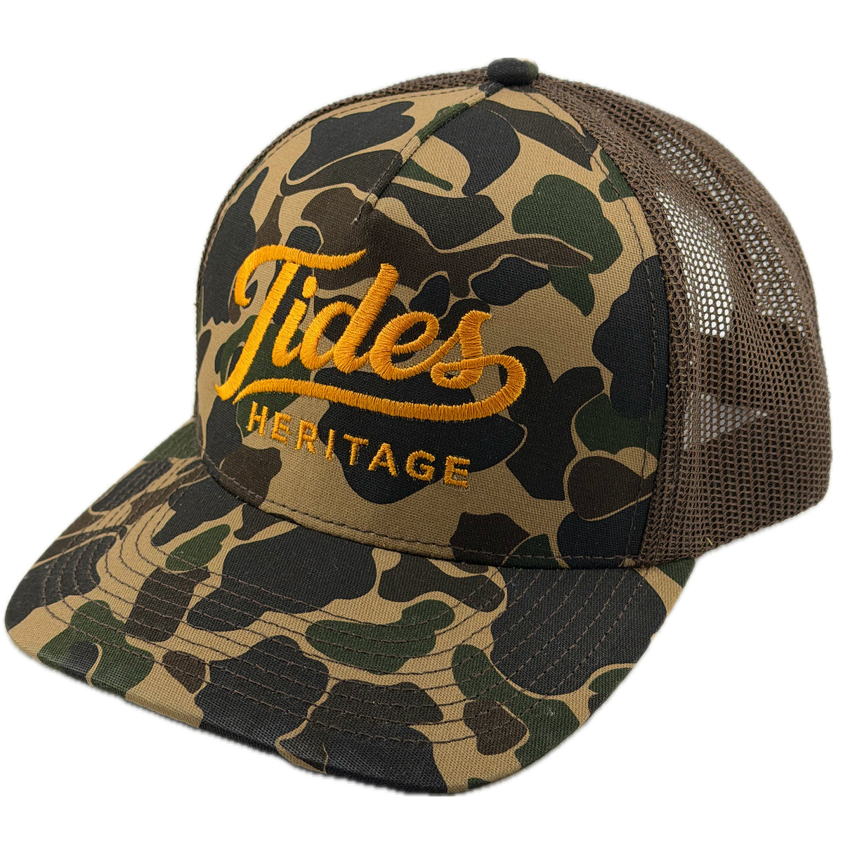 A trucker-style cap featuring a green and brown camouflage pattern on the front panel and brim, with a dark brown mesh back. The front is embroidered with 'Tides HERITAGE' in yellow-gold thread.  THE BRAND IS TIDES HERITAGE AND FEATURES A DUCK CAMO.  